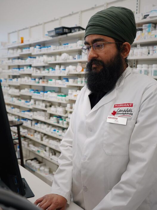 A pharmacist handling a prescription at the counter, illustrating formulary and tiering exception requests
