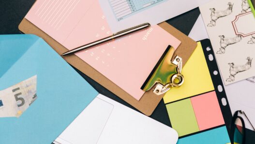 Person paying monthly bills with a calendar, illustrating getting one month ahead on bills