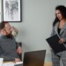 Two coworkers discussing pay at a desk during a salary planning meeting