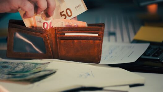 Bank statement and coins on a desk representing a forgotten inactive bank account