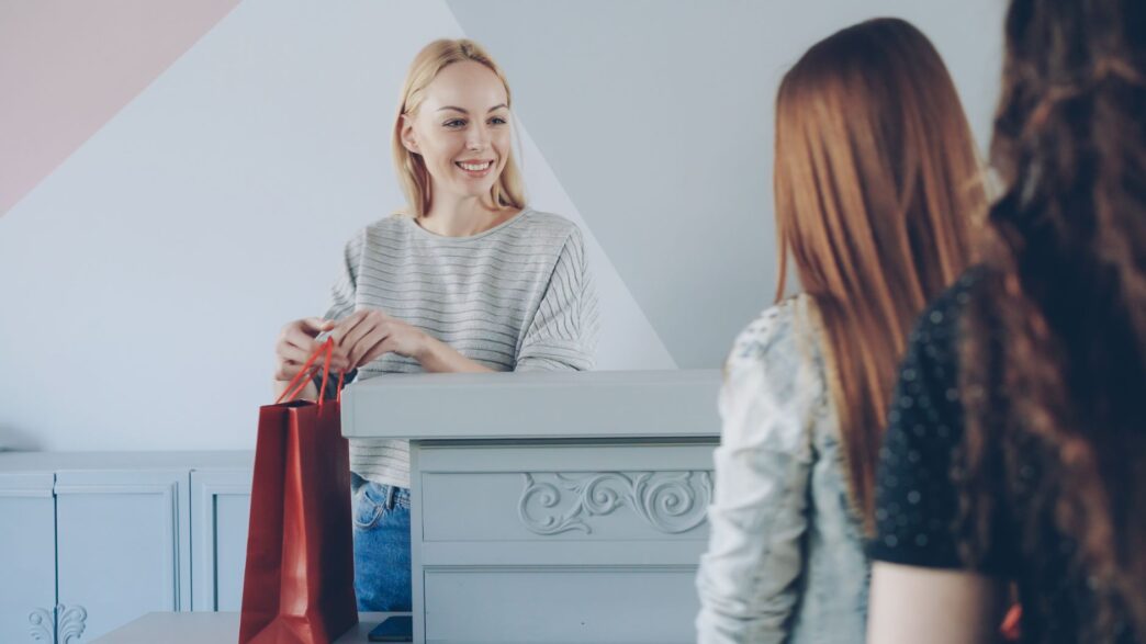 Holiday shopper carrying store bags past a retail checkout counter