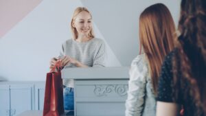 Holiday shopper carrying store bags past a retail checkout counter