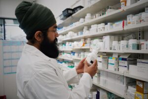 Pharmacist handing prescription medication to a customer at a pharmacy counter