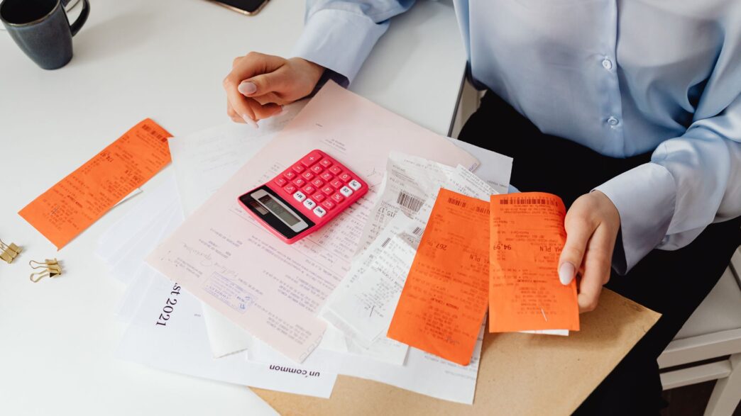 Medical billing paperwork and a calculator, illustrating tracking an out-of-pocket maximum