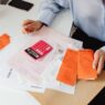 Medical billing paperwork and a calculator, illustrating tracking an out-of-pocket maximum