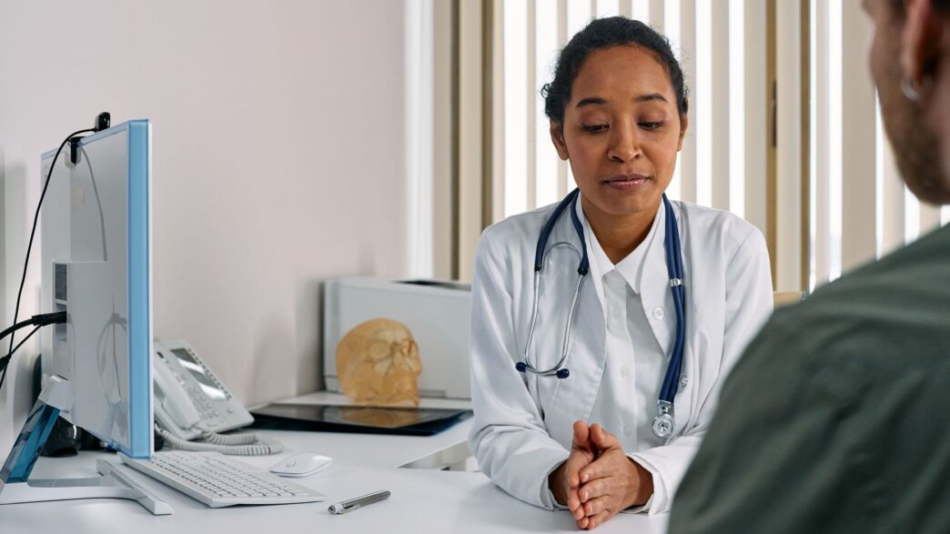 A doctor reviewing paperwork with a patient, illustrating the prior authorization denial appeal process