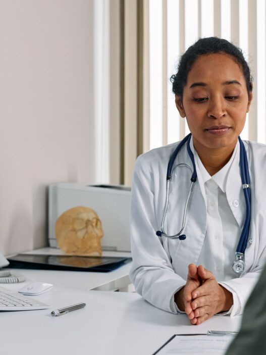 A doctor reviewing paperwork with a patient, illustrating the prior authorization denial appeal process