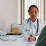 A doctor reviewing paperwork with a patient, illustrating the prior authorization denial appeal process