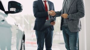Car keys resting on a signed auto loan contract at a dealership desk