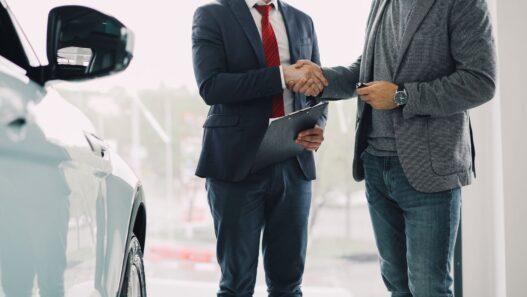 Car keys resting on a signed auto loan contract at a dealership desk
