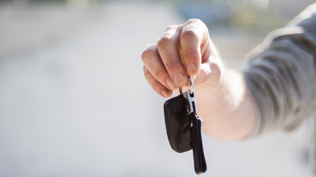 A rental car counter with keys on the desk, illustrating rental car insurance coverage decisions