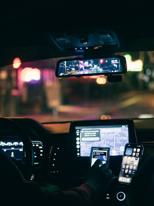A driver using a rideshare app in a car, illustrating the rideshare insurance gap between coverage periods