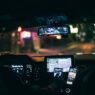 A driver using a rideshare app in a car, illustrating the rideshare insurance gap between coverage periods