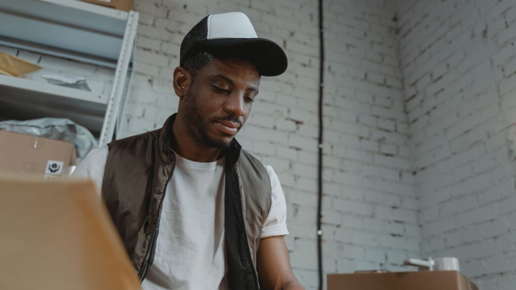Seasonal warehouse worker sorting packages during a holiday shift