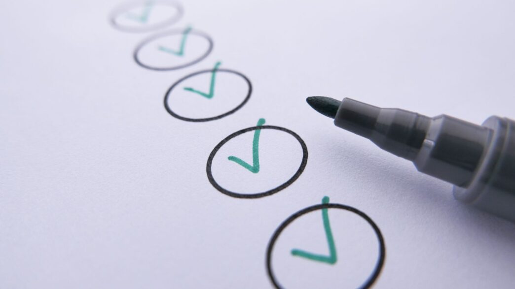 Person writing a paper check from a checkbook
