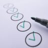 Person writing a paper check from a checkbook