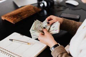 Hands counting cash dollar bills from a paycheck