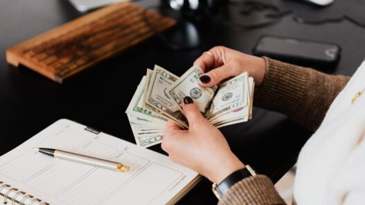 Hands counting cash dollar bills from a paycheck