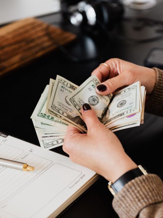 Hands counting cash dollar bills from a paycheck