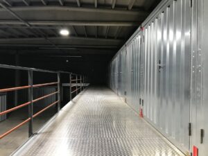 Row of self storage unit doors along an indoor facility hallway