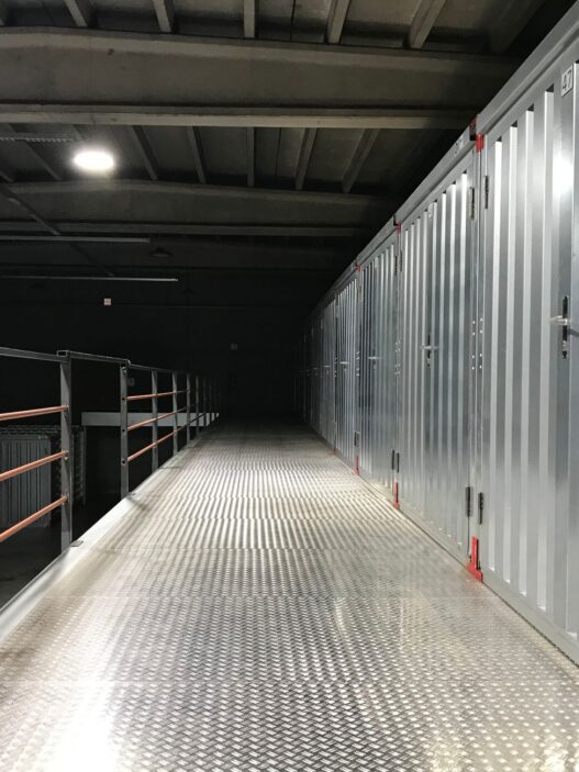 Row of self storage unit doors along an indoor facility hallway