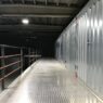 Row of self storage unit doors along an indoor facility hallway