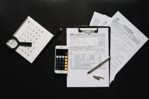 Federal tax return forms and a calculator on a desk before the October 15 extension deadline