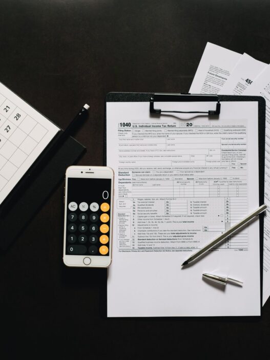 Federal tax return forms and a calculator on a desk before the October 15 extension deadline