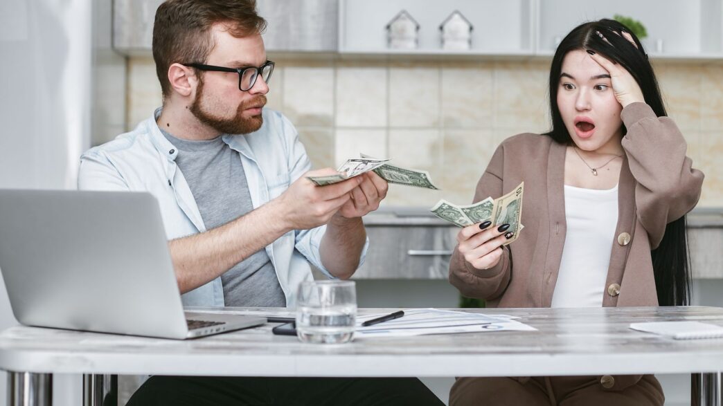A young family reviewing household finances and insurance paperwork at home