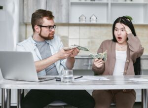 A young family reviewing household finances and insurance paperwork at home