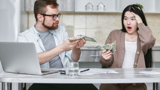 A young family reviewing household finances and insurance paperwork at home
