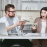 A young family reviewing household finances and insurance paperwork at home