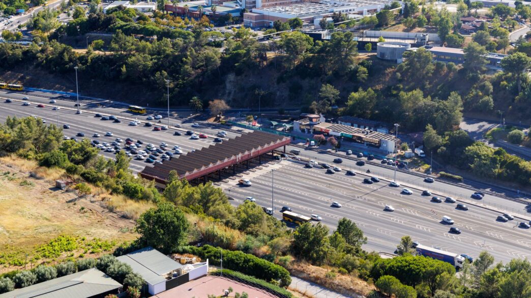 Cars passing under an electronic toll gantry on a highway