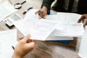 Open enrollment benefits paperwork and a calculator on a desk
