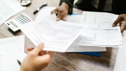 Open enrollment benefits paperwork and a calculator on a desk