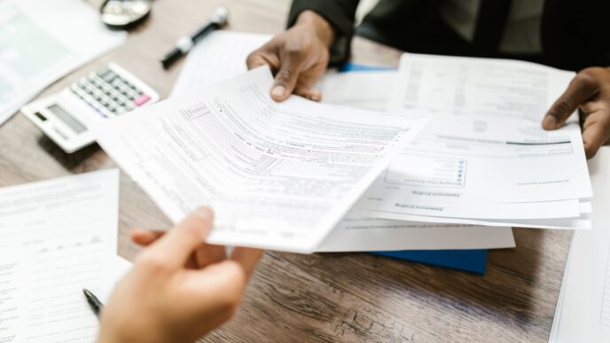 Open enrollment benefits paperwork and a calculator on a desk