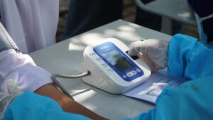 Nurse taking a patient's blood pressure during a workplace health screening