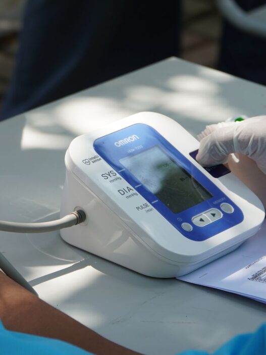Nurse taking a patient's blood pressure during a workplace health screening