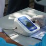 Nurse taking a patient's blood pressure during a workplace health screening
