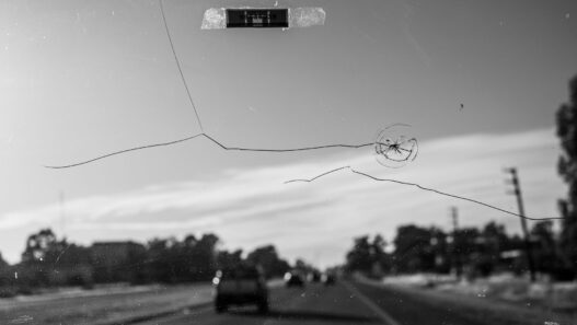 A cracked vehicle windshield, illustrating windshield insurance claim costs including ADAS recalibration