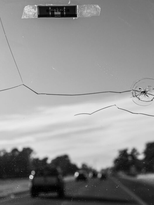 A cracked vehicle windshield, illustrating windshield insurance claim costs including ADAS recalibration