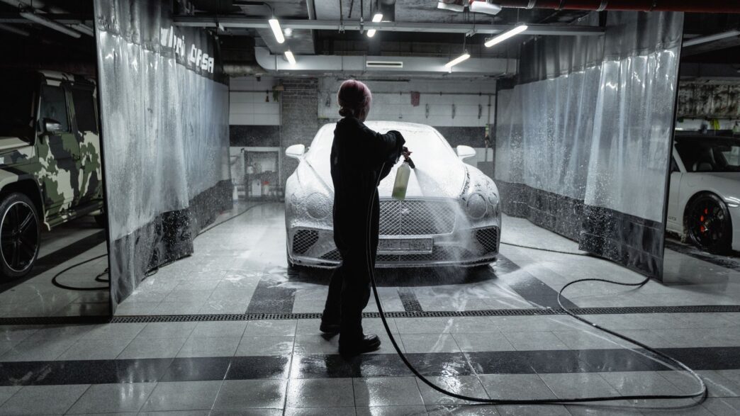 Car going through an automatic car wash tunnel covered in foam
