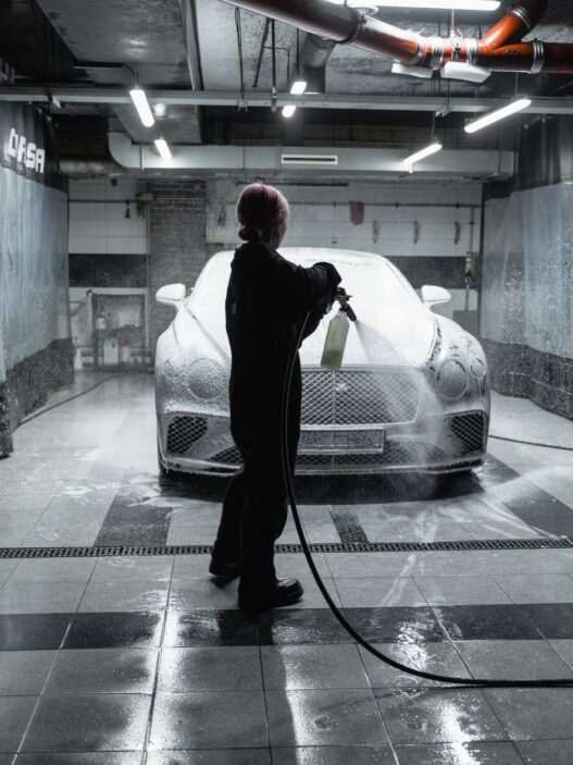 Car going through an automatic car wash tunnel covered in foam