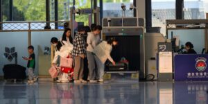 Travelers waiting in line at an airport security checkpoint during busy holiday travel
