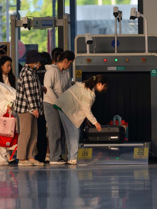 Travelers waiting in line at an airport security checkpoint during busy holiday travel