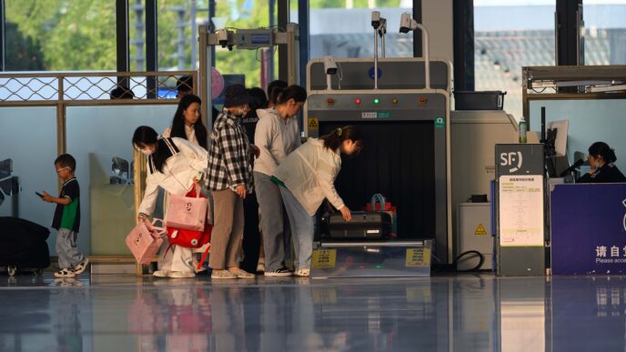 Travelers waiting in line at an airport security checkpoint during busy holiday travel