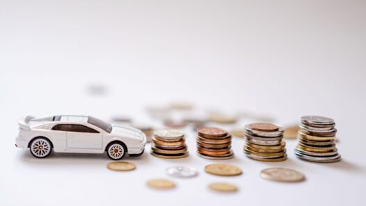 Piggy bank beside car keys, representing a sinking fund for paying car insurance in full